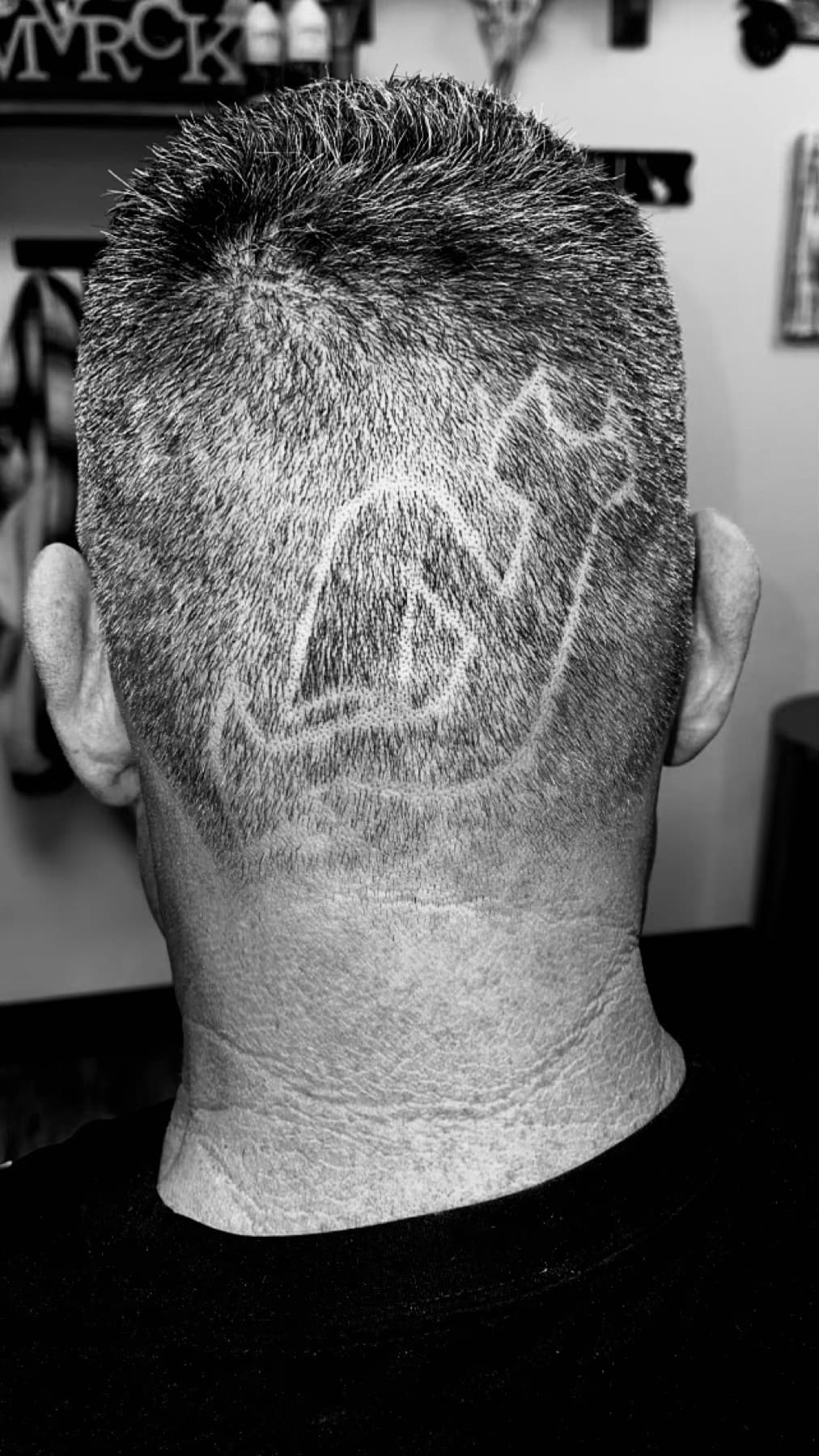 Detailed freehand design shaved into the back of the head