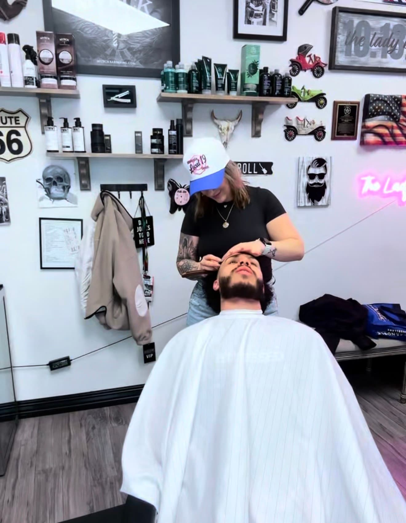 Jenna working on a client leaning back in the barber chair