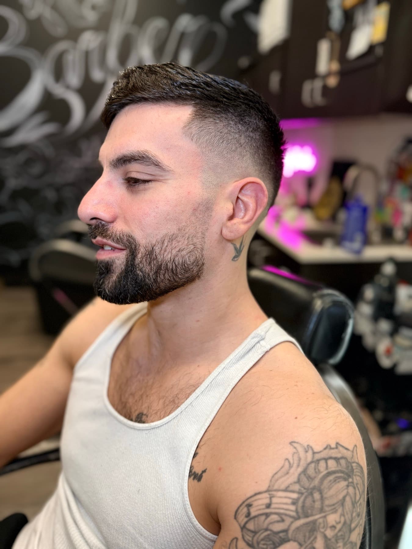 Skin fade with a sharp beard in front of the mural wall